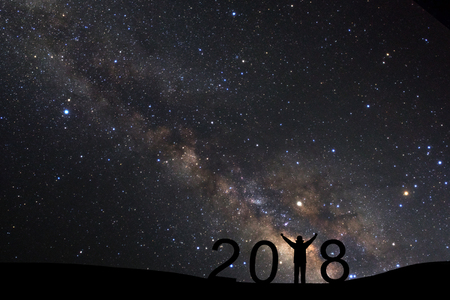 silhouette of a standing sporty man for Happy New Year 2018 background on with milky way, Night sky...