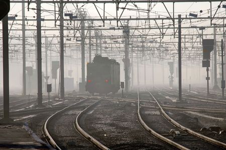 Train with red signal lights in early morning fog in Brugges, Belgium
