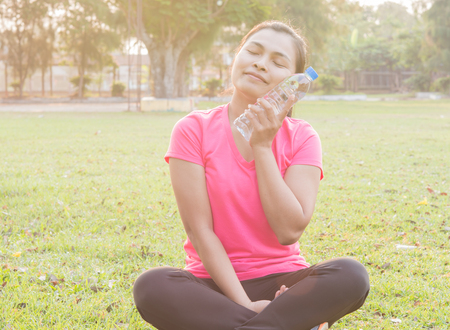 Women exercise with drinking water in the garden
