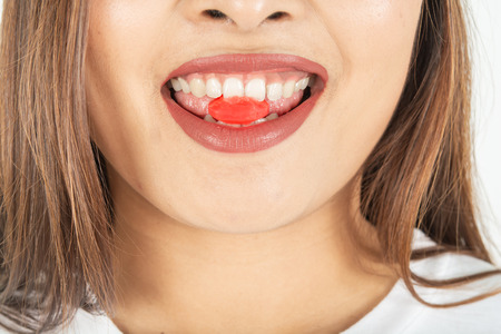Red candy in the mouth and dark red lipstick of womenの写真素材