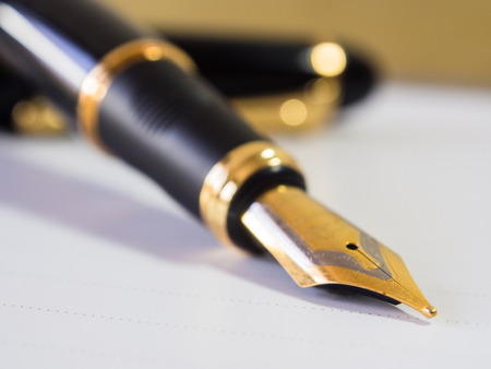 Fountain pen  shot with shallow depth of field on white paper.の写真素材
