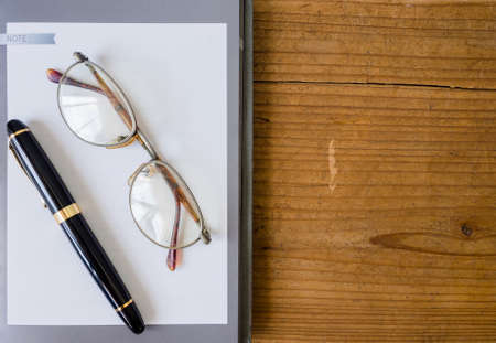 White paper in gray frame with pen and sunglassesの写真素材