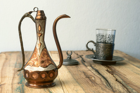 Turkish teapot with arabic decoration with metal cup and dish in vintage colorの写真素材