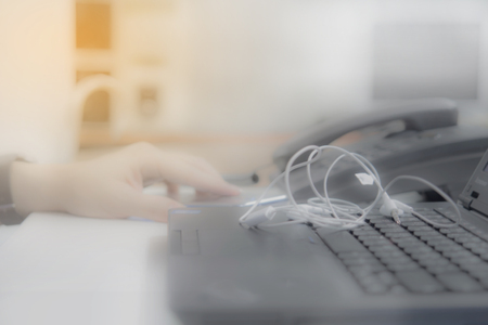 Blurred office desk with laptop and telephoneの写真素材