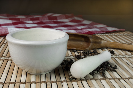 Mortar and dried herbs on bamboo matの写真素材