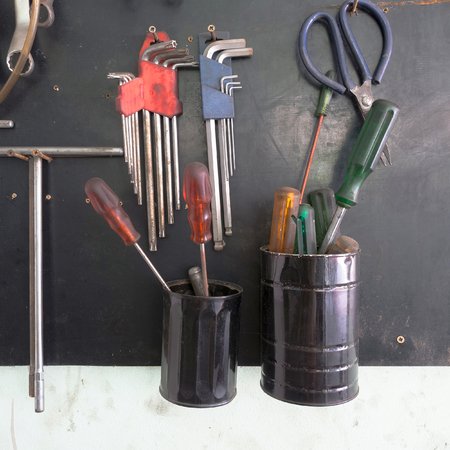 Dirty set of hand tools on a wooden panel And part in the cans.