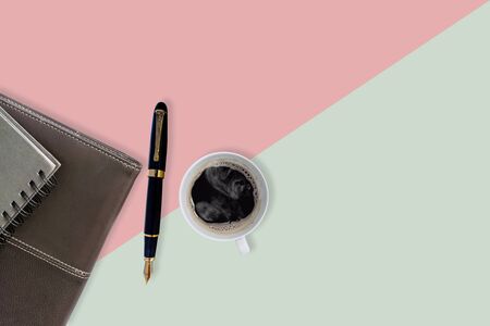 Sweet color office table with fountain pen , notebook and cup off coffeeの写真素材