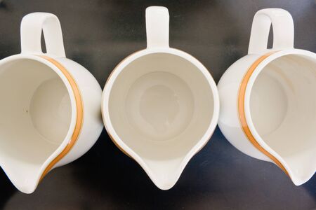 Three empty porcelain jugs for fiil in with milk or creamの写真素材