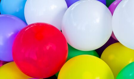 A red balloon between other   colorful balloonsの写真素材