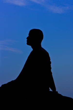 Silhouette of monk meditating at the top of the mountainの写真素材