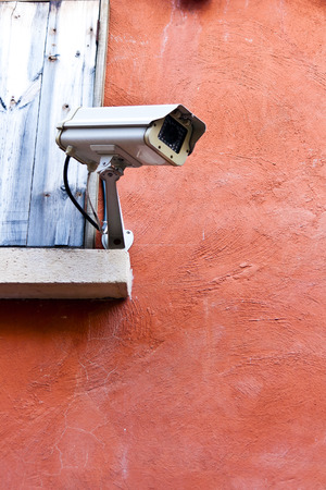 Brown grunge textured concrete wall with CCTV