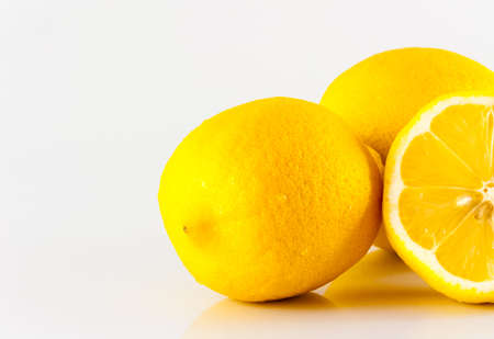 Three lemons, one cut in half Looks fresh and tasty. Against a white backdropの写真素材