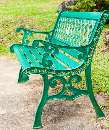 Green metal bench in the park. Relaxing with plant and treeの写真素材