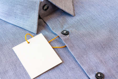 Small gray stripes men's shirt with a price tag and yellow-orange tag lanyardの写真素材