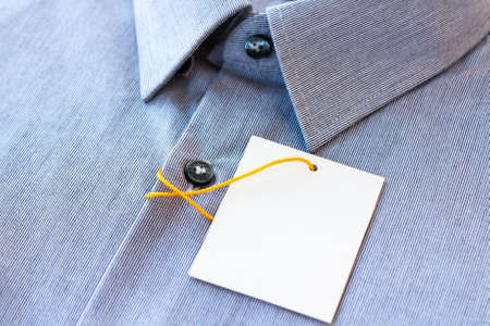 Small gray stripes men's shirt with a price tag and yellow-orange tag lanyardの写真素材