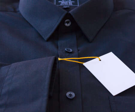 Dark men's shirt with a price tag and yellow-orange tag lanyardの写真素材