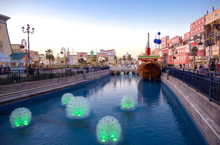 DUBAI, UAE, DEC-16 2020 Beautiful view of the country pavilions ,and Canal with illuminated boats in the park entertainment center captured in the evening sunset time at The Global Village.のeditorial素材