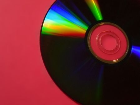 colourful cd in corner of red backdropの写真素材