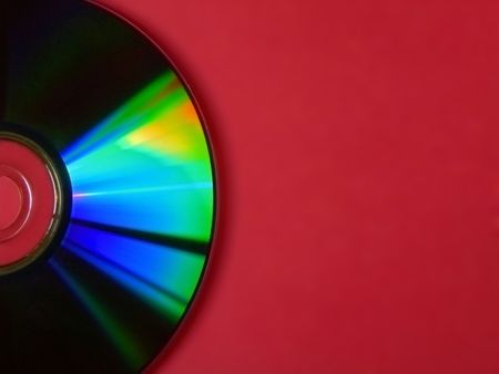 shot of half a colourful cd on red backdropの写真素材