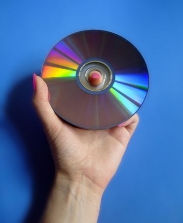 woman holding a colourful cd on blue backgroundの写真素材