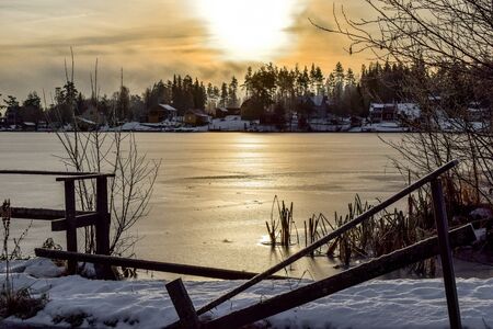 Morning sun over a ice covered lakeの写真素材