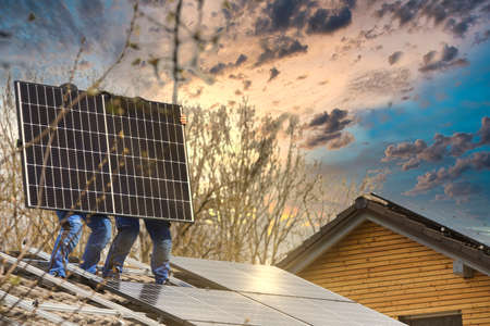 Solar panels installed on the roof of a private house against the background of a blue sky.の写真素材