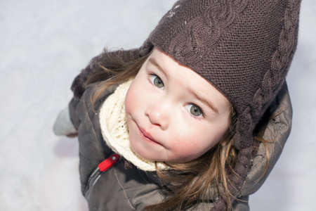 A cute little girl in a snowy backgroundの写真素材