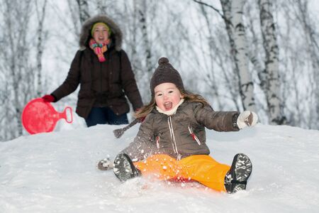 A little girl sliding down a hillの写真素材