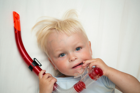 A cute little boy playing with snorkeling tubeの写真素材
