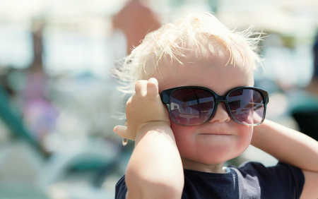 A cute little boy trying on the sunglassesの写真素材