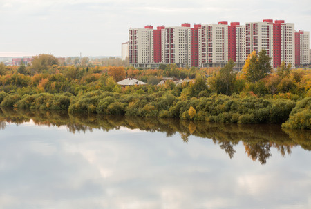 Residential apartments on a river bank in autumnの写真素材