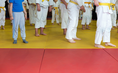 Children in kimono warming up on tatami on martial arts training. Selective focusの写真素材