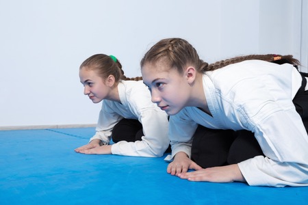 Two girls in black hakama bow on Aikido trainingの写真素材