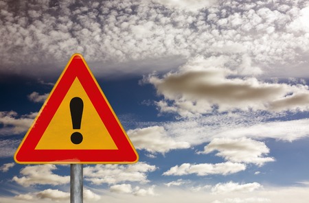 Danger ahead warning road sign on a dramatic skyの写真素材