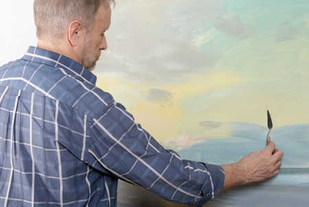 An artist painting with a palette knife in studio. Selective focusの写真素材