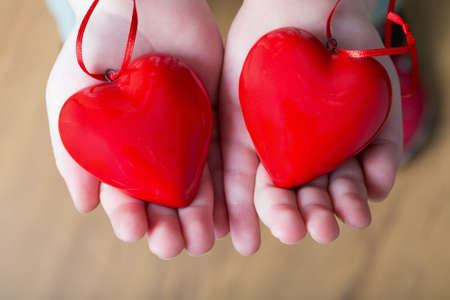 Two red hearts in child's handsの写真素材