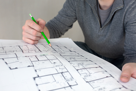 A construction worker on a construction site check documents with pencil in his hand. Selective focusの写真素材