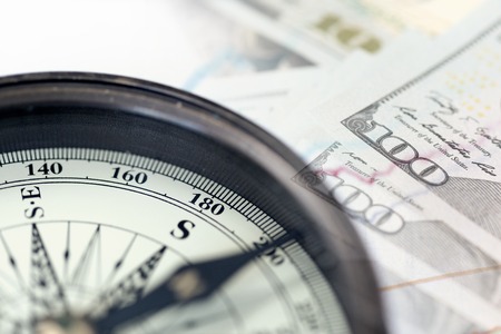 A collage with compass and US dollar bills.の写真素材