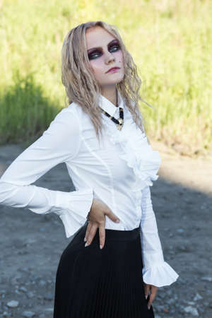 An outdoor fashion gothic style portrait of a beautiful blonde girlの写真素材