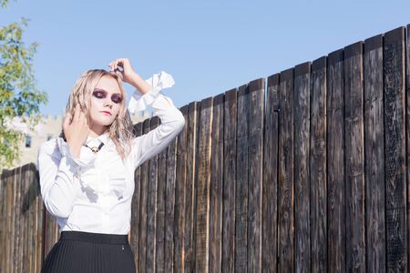 An outdoor fashion gothic style portrait of a beautiful blonde girl