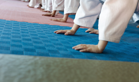 Group of children in kimono pushing-ups from the tatami on martial arts training. Selective focusの写真素材