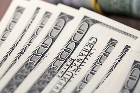 A pile of one hundred US dollar bills on a table.の写真素材