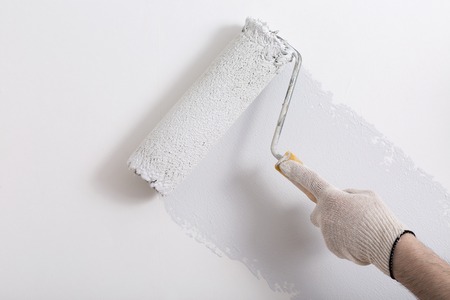 Close up of painter arm painting a wall in gray with paint rollerの素材 [FY31061597346]