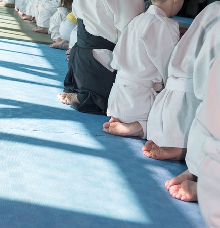 Group of children in kimono sitting on tatami on martial arts training seminar. Selective focusの写真素材