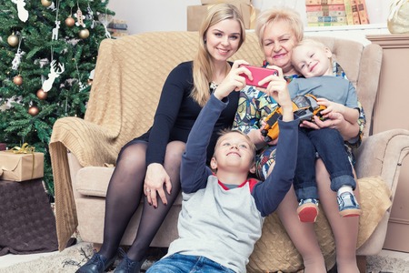 Happy family taking pictures with smartphone on Chistmas decorations
