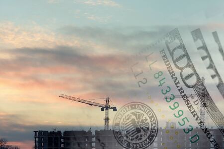 Collage with construction site at suset and US dollarsの写真素材