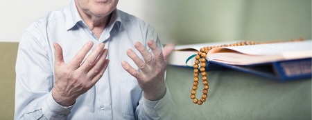 The Koran and praying hands of muslim old manの写真素材