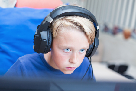 Teenage boy playing computer games on PC