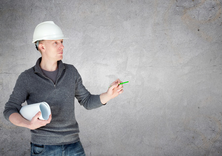 An engineer in white helmet holding blueprintsの写真素材