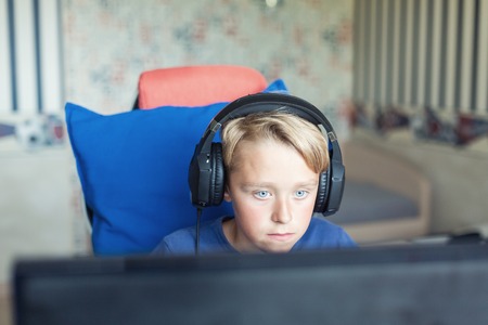 Teenage boy playing computer games on PCの写真素材